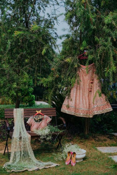 Photo of Getting ready shot ideas with bridal lehenga and blouse on hanger