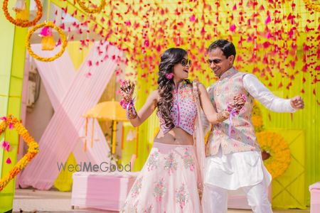 Photo of A coordinated bride and groom dance on their mehendi function.