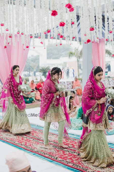 Photo of Bridesmaids in coordinated outfits of pink and green