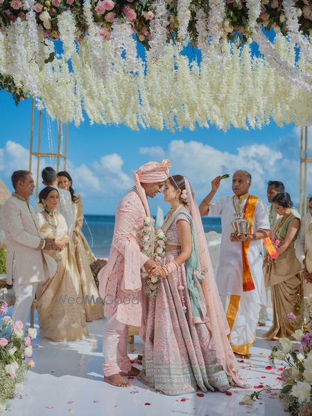 Photo of bright and happy couple shot post wedding by the beach