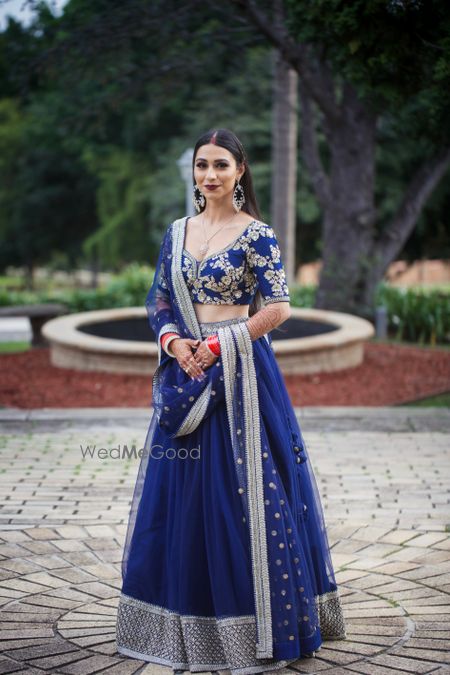 Photo of Bride in dark blue designer lehenga.