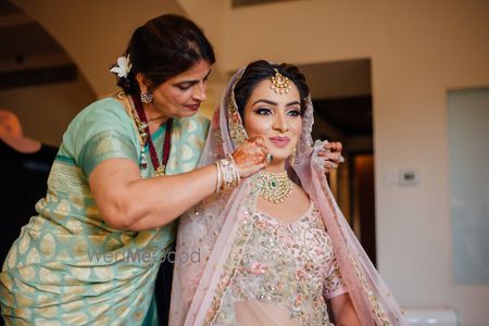 Photo of Brides mom putting dupatta on her head