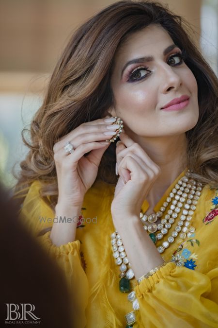 Photo of bride getting ready wearing her jewellery shot on mehendi