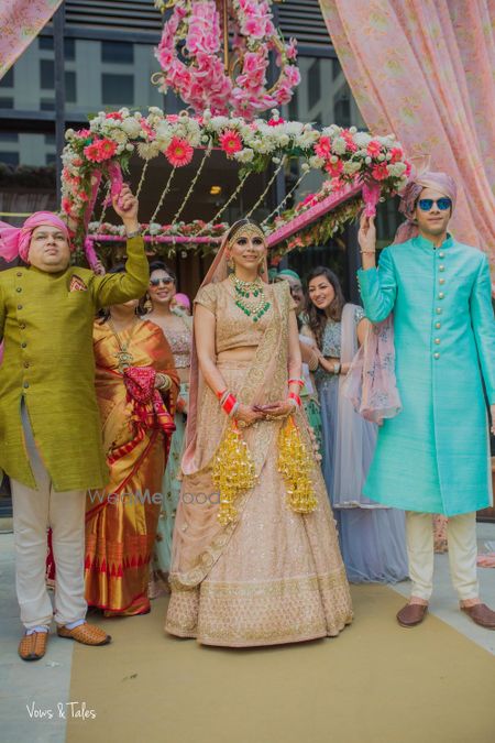 Photo of Bride in peach entering under pink phoolon ka chadar