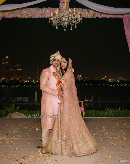 Photo of Light pink bride and groom sherwani