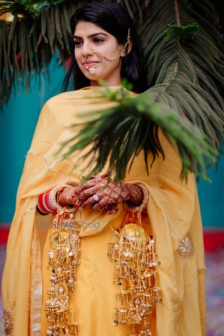 Photo of A bride in a simple yellow outfit her haldi