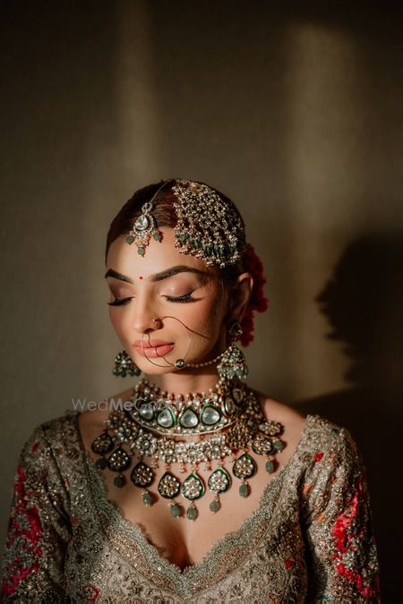 Photo of Lovely bridal shot with bride wearing statement polki and jadau jewellery with a statement passa