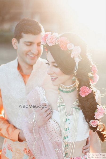 Photo of Mehendi hairstyle with pink carnations in braid