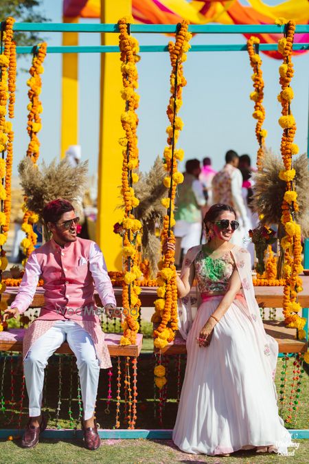 Photo of mehendi bridal and groom seating idea with jhoolas