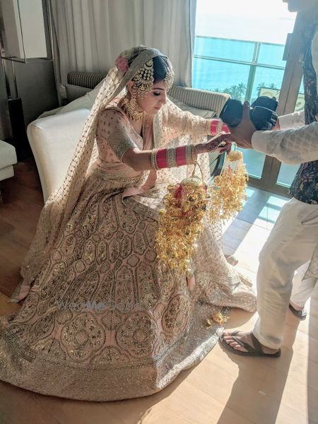 Photo of bride with her bridal kaleere in a pink and gold lehenga