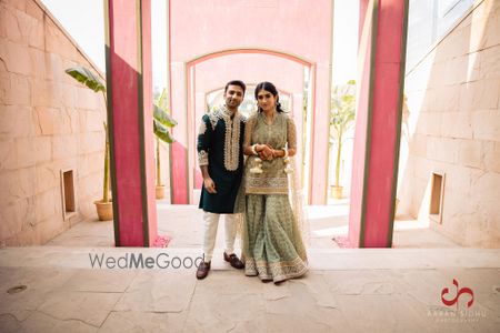 Photo of Bride and groom dressed in shades of green.