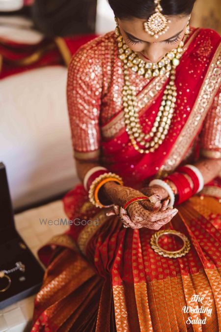 Photo of Bride close up shot putting on jewellery getting ready