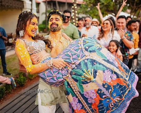 Photo of Fun capture of the groom picking the bride on the haldi day