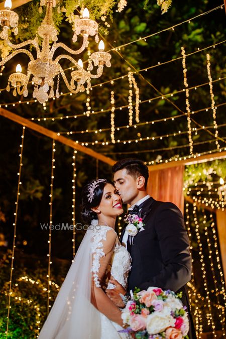 Photo of A cute couple shot, groom kissing the bride.