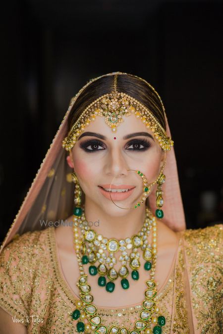 Photo of Layered bridal contrasting jewellery with peach makeup