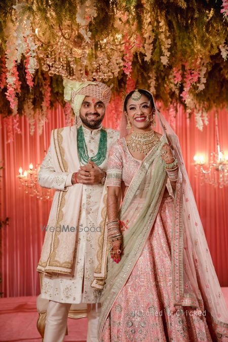 Photo of pastel bride and groom matching with the stage decor