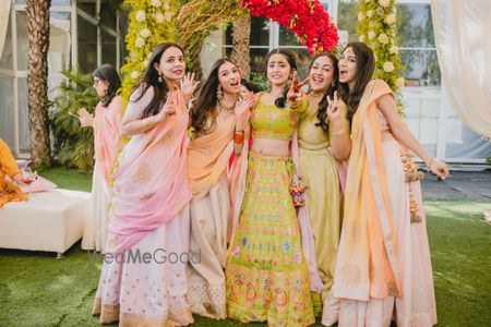 Photo of Bride with bridesmaids on mehendi in green lehenga