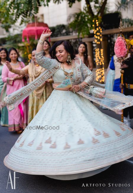 Photo of Brides mom dancing in powder blue lehenga