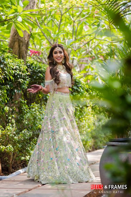 Photo of Happy bride shot in light green lehenga on mehendi