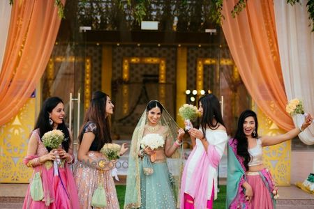 Photo of A fun bridesmaid shot with matching bouquets and coordinated outfits