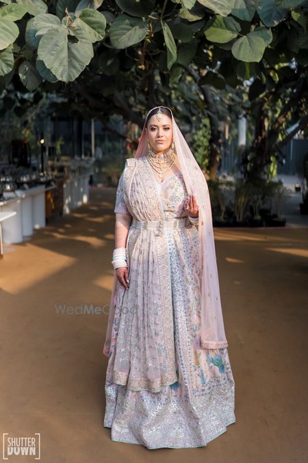 Photo of Bride in a pastel lehenga with all over embroidery