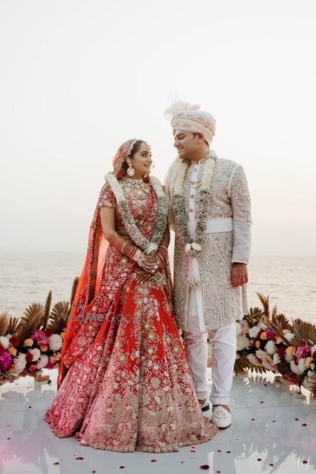 Photo of happy couple post their jaimala exchange on beach mandap