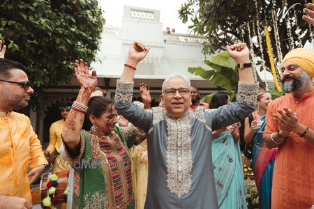 Photo of Cute candid moment where the father and mother of the bride dance their heart out at the mehendi