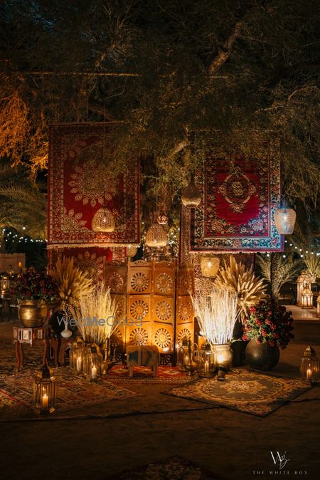 Photo of Middle eastern themed sangeet decor with hanging carpets and pampas grass