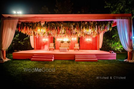 Photo of unique jaimala stage with hanging floral decor in peach theme