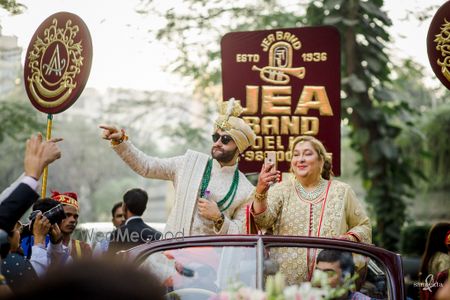 Photo of Groom in a vintage car for his baraat with his mother by his side