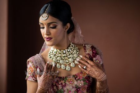 Photo of contrasting polki bib necklace on bride with sabyasachi lehenga