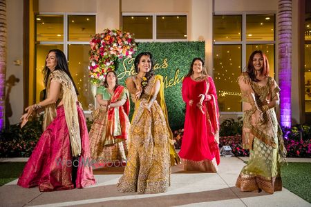 Photo of Bride and bridesmaids dancing on mehendi together