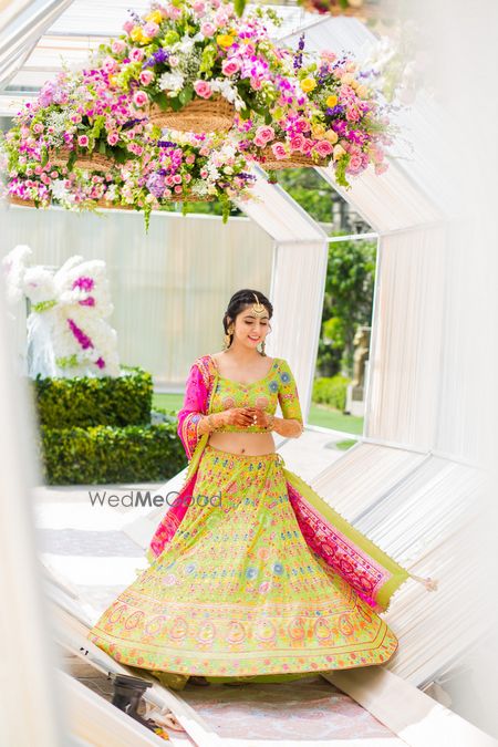 Photo of Bride in lime green and pink lehenga on mehendi