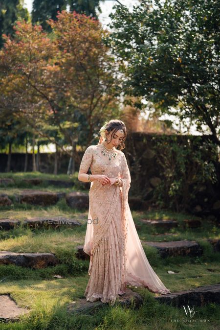 Photo of Gorgeous wedding day bridal portrait with the bride in a peach saree and emerald jewels