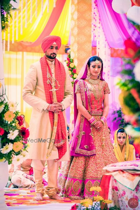 Photo of Bride in Pink Lehenga and Groom in Pink Pagdi