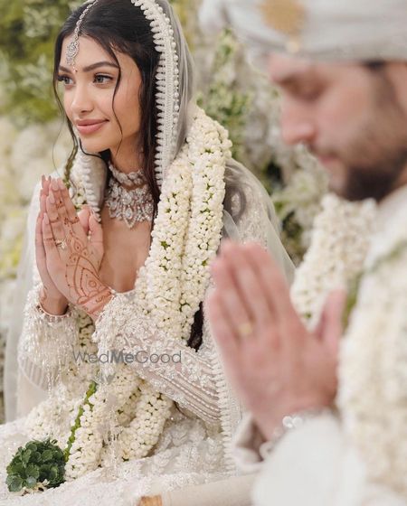 Photo of Alanna and Ivor in white custom Manish Malhotra outfits on their wedding day  during varmala