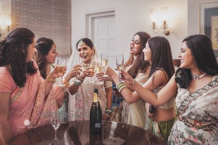 Photo of bride raising a toast with her squad