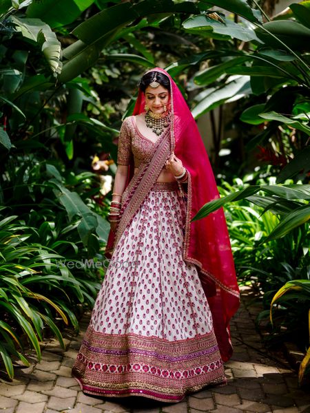 Photo of Bride dressed in an ivory and red bridal lehenga,