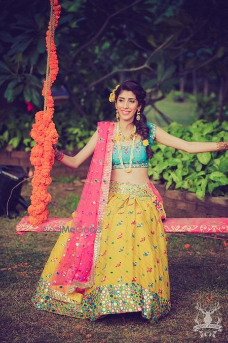 Photo of bright colorblocked lehenga in leheriya yellow pink and blue with mirror work detailing