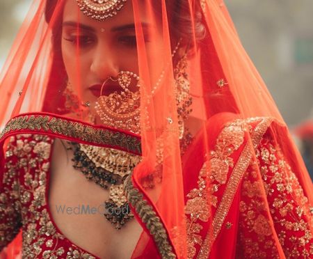 Photo of Bridal portrait with bride in oversized Nath and veil