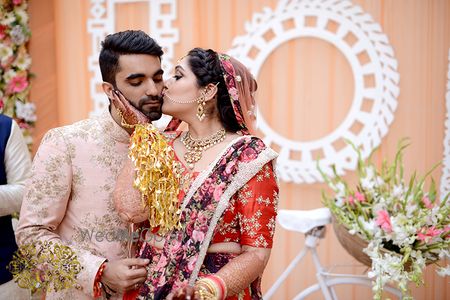 Photo of Bride giving kiss to groom at Indian wedding