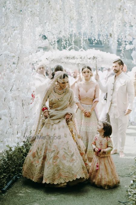 Photo of cute bridal entry portrait with kid under phoolon ki chadar