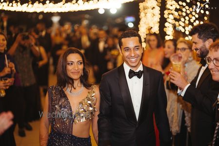 Photo of Super glamorous gold blouse with a navy saree with plunge neck detailing for the bride