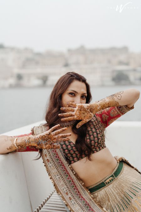 Photo of Cute bridal portrait of the bride posing with her mehendi design