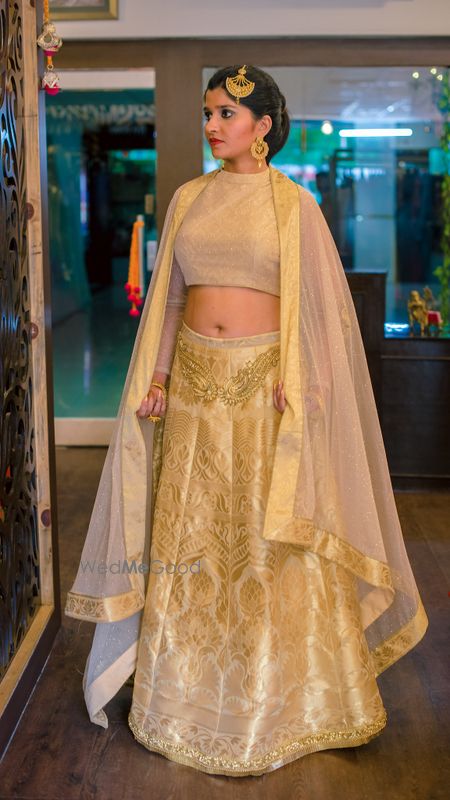 Photo of Gold and beige lehenga with cape