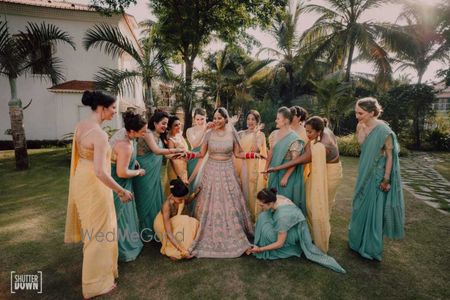 Photo of bride and bridesmaid shot on wedding day helping her