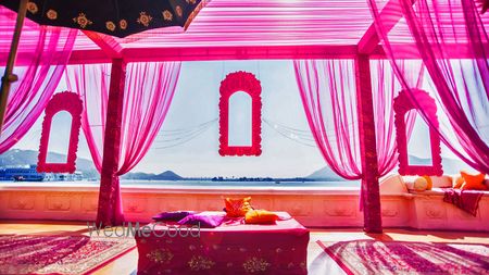 Photo of mehendi raani pink theme with frames and drapes overlooking sea