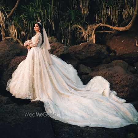 Photo of A beautiful Christian bride in a stunning white gown with a train.