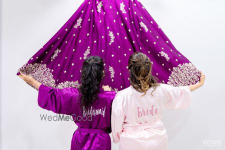 Photo of Bride with bridesmaid getting ready in robe