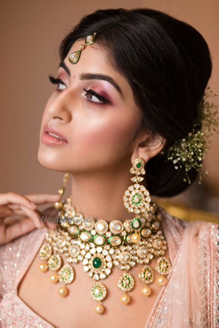 Photo of Light pink engagement makeup and bun with babys breath